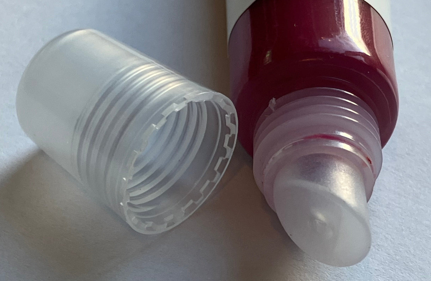 Barbie pink lip gloss tube with clear cap on a white background